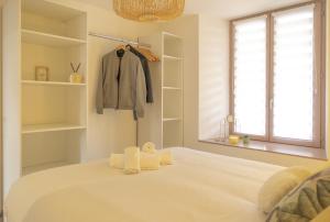 a bedroom with a white bed with towels on it at Au Fil de l'Eau - Cosy in Barr