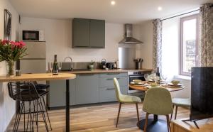 a kitchen with a table and chairs and a dining room at Au Fil de l'Eau - Cosy in Barr