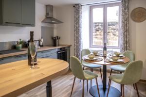 a kitchen with a table and chairs and a window at Au Fil de l'Eau - Cosy in Barr