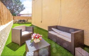 a patio with two chairs and a couch and a table at Bungalow moderno con terraza privada y BBQ a 5 min de la playa in Torrevieja