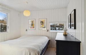 a white bedroom with a bed and a table at 4 Bedroom Gorgeous Home In Hornbæk in Hornbæk +13 photos