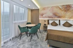 Una habitación de hotel con una cama, una mesa y sillas. en Wellness Hotel Astra, en Špindlerův Mlýn 89 fotos más