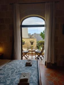 a bedroom with a bed and a large window at Laremi Gozo B&B in Nadur