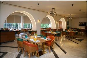 a dining room with tables and chairs in a restaurant at SRM Hotel Maraimalai Nagar Chennai in Gūduvāncheri