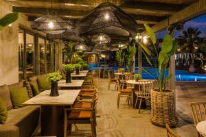 a restaurant with tables and chairs and potted plants at Avithos Resort Hotel in Svoronata