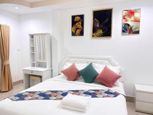 Sathani Khlong RianにあるDream Homestay Hat Yaiの白いベッドルーム(カラフルな枕付きのベッド1台付)