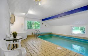 a pool with a table and a swimming pool at Holiday Home Møllevangen in Ovtrup