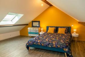 una camera da letto con un letto con pareti gialle e una finestra di Une Parenthèse Carolo a Charleville-Mézières