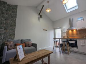 a living room with a couch and a table at Le Bohème, sauna & spa in Riorges