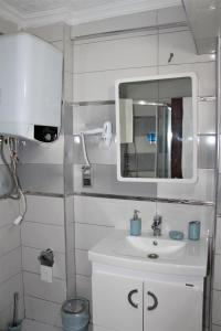 une salle de bain avec un lavabo et un miroir dans l'établissement Mavi Restaurant & Apartments 1, à Didim 26 autres photos