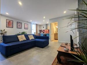 a living room with a blue couch and a table at Le Riad, sauna & jacuzzi in Riorges