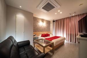 a hotel room with a bed and a couch at ルトゥール姫路 Retur HIMEJI 男塾ホテルグループ in Himeji +21 photos