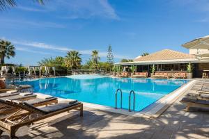 a large swimming pool with chaise lounges next to a resort at Avithos Resort Hotel in Svoronata