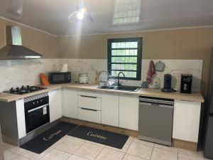 a kitchen with white cabinets and a stove top oven at Mon ti kréoline in Le Tampon