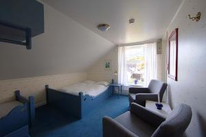 ein Zimmer mit einem Bett, einer Couch und einem Stuhl in der Unterkunft Nes Gard in Høyheimsvik