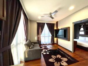 a living room with a couch and a tv at Grace Hotel Semporna in Semporna