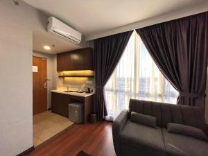 a living room with a couch and a kitchen at Grace Hotel Semporna in Semporna