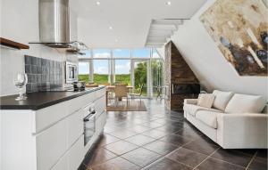 a kitchen and living room with a couch and a table at Holiday Home Marievænget in Tørresø +16 photos