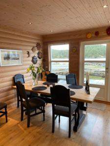 a dining room with a wooden table and chairs at Moderne Rorbu helt i sjøkanten in Hauge
