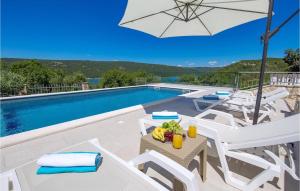 una piscina con sedie bianche e un tavolo con frutta e un ombrellone di Villa Lucija Dream a Trgetari