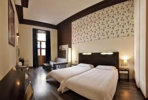 マドリードにあるAlhambra Suitesの大きな白いベッドと椅子のある寝室