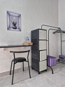 a desk with a chair and a table and a shelf at Juliana HomeStay in Dorobanggo