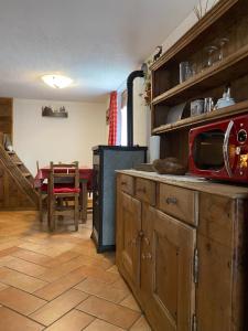 a kitchen with wooden cabinets and a table with a microwave at Da Fanny in Cogne