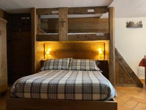 a bedroom with a bed with a wooden headboard at Da Fanny in Cogne