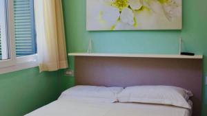 a bed with two pillows in a green bedroom at Appartamento Roero cottage 3 in Alba +12 photos