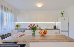 a kitchen with a table with a bowl of fruit at Villa Mendula in Potpićan
