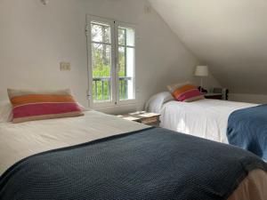 a bedroom with two beds and a window at La Casita de la Playa Escondida in Tal