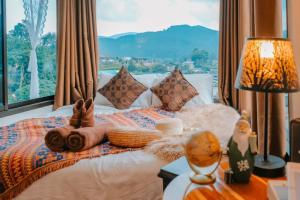 ein Schlafzimmer mit einem Bett mit einem großen Fenster in der Unterkunft Ping fai camp inthanon in Chiang Mai