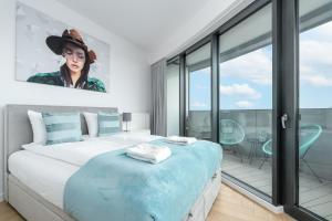 a bedroom with a bed with a painting of a woman at MARGI Flair Apartament POOL SAUNA JACUZZI in Szczecin +12 photos