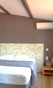 a bedroom with a bed and a brick wall at Le Patio Bleu in La Crau