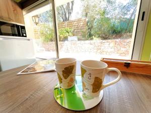two coffee mugs sitting on top of a table at Le Patio Bleu in La Crau