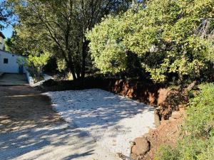 a driveway with trees and a brick wall at Le Patio Bleu in La Crau