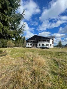 a large house with two cars parked in a field at Weinesya Sunset Smida in Beliş