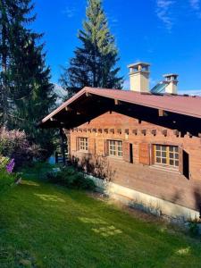 a brick house with a grass yard in front of it at Chalet de charme - vue panoramique in Combloux