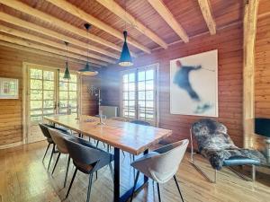 a dining room with a large wooden table and chairs at Chalet de charme - vue panoramique in Combloux