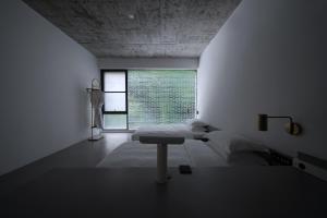 a white room with a bed and a window at Geemu Resort Yangshuo in Yangshuo