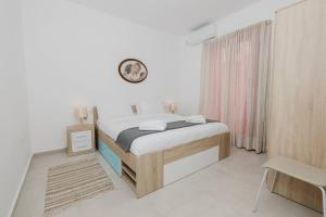 a bedroom with a bed and a clock on the wall at Seaside 2bed Apartment Ghadira! By Homely in Mellieħa