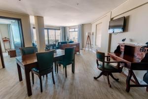 a living room with a dining room table and chairs at Beach Hotel Swakopmund in Swakopmund