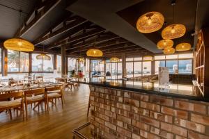 a restaurant with a brick wall and tables and chairs at Beach Hotel Swakopmund in Swakopmund