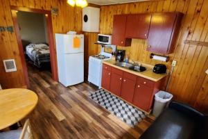 a small kitchen with a white refrigerator and a table at Marina View 1 Bedroom Sunset Cabin in Kabetogama