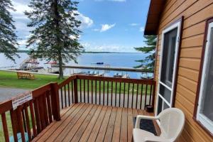 a deck with a white chair and a view of the water at Marina View 1 Bedroom Sunset Cabin in Kabetogama