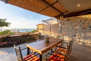 una mesa y sillas en un patio con una pared de piedra en Verga Paradise Nest - A Blissful Hideout, en Almirón