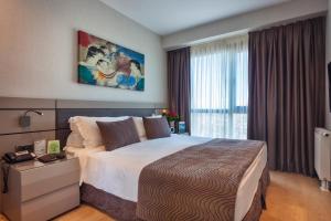 a hotel room with a large bed and a window at Fraser Place Antasya Istanbul in Istanbul