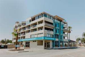 a building on the beach with palm trees at Beach Hotel Swakopmund in Swakopmund