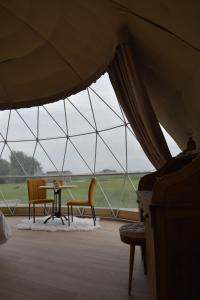 a tent with a table and chairs in a room at Domein de Koekoeksvlooghe in Lo-Reninge +24 photos