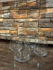 four empty wine glasses sitting on a wooden table at Милый Дом in Vanadzor +11 photos